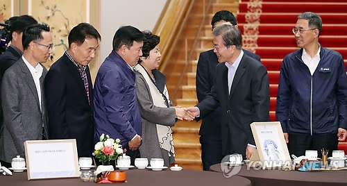 President Moon Jae-in (2nd from R) shakes hands with an official from a local labor union before the start of a meeting with the labor leaders at the presidential office Cheong Wa Dae in Seoul on Oct. 24, 2017. (Yonhap)