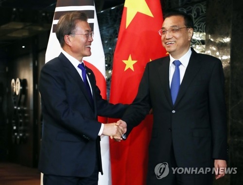 South Korean President Moon Jae-in (L) and Chinese Prime Minister Li Keqiang shake hands before the start of their bilateral talks, held on the sidelines of the Association of Southeast Asian Nations forum in Manila, the Philippines on Nov. 13, 2017. (Yonhap)