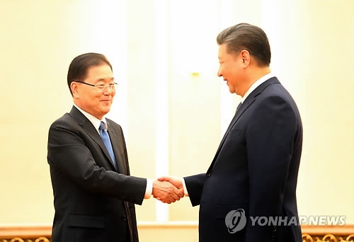 Chinese President Xi Jinping (R) shakes hands with South Korea's National Security Office chief Chung Eui-yong in Beijing on March 12, 2018. (Yonhap) 
