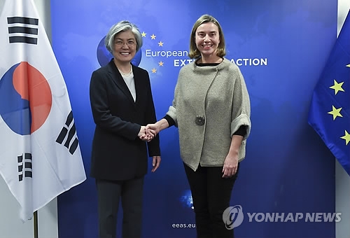 South Korean Foreign Minister Kang Kyung-wha (L) shakes hands with EU High Representative for Foreign Affairs and Security Policy Federica Mogherini in Brussels on March 18, 2018. (AP-Yonhap)