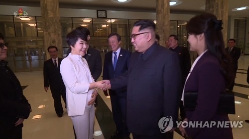 North Korean leader Kim Jong-un (front, C) shakes hands with South Korean singer Choi Jin-hee (L) at East Pyongyang Grand Theatre in the North's capital after a concert by a South Korean art troupe on April 1, 2018. This photo was captured from a North Korean Central TV broadcast the following day. (Yonhap)