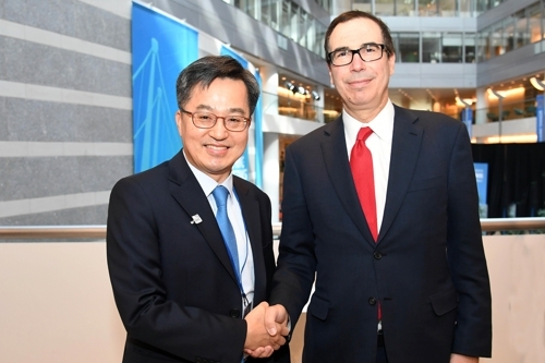 South Korean Finance Minister Kim Dong-yeon (L) shakes hands with U.S. Treasury Secretary Steven Mnuchin before a meeting in Washington, on April 21, 2018. (Yonhap)
