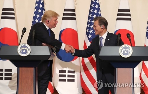 The file photo, taken Nov. 7, 2017, shows South Korean President Moon Jae-in (R) and U.S. President Donald Trump shaking hands in a joint press conference following their bilateral summit in Seoul. (Yonhap)