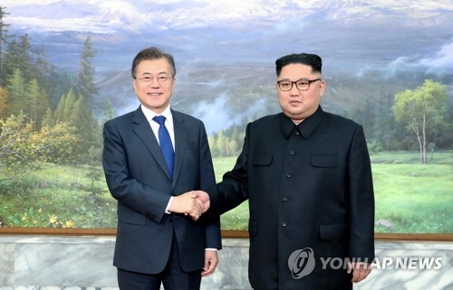 The photo, provided by South Korea's presidential office Cheong Wa Dae, shows South Korean President Moon Jae-in (L) and North Korean leader Kim Jong-un shaking hands before their second bilateral summit in less than a month held at the border village of Panmunjom on May 26, 2018. (Yonhap)