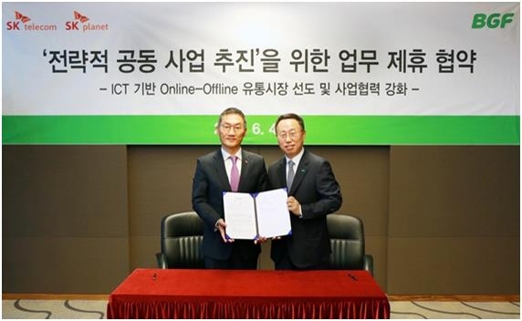 In this photo provided by BGF Co., the investment unit of South Korea's largest convenience store chain CU, its head Lee Keon-jun (R) poses for a photo with SK Planet Co. chief Lee Inn-chan during a partnership signing ceremony in Seoul on June 4, 2018. (Yonhap)