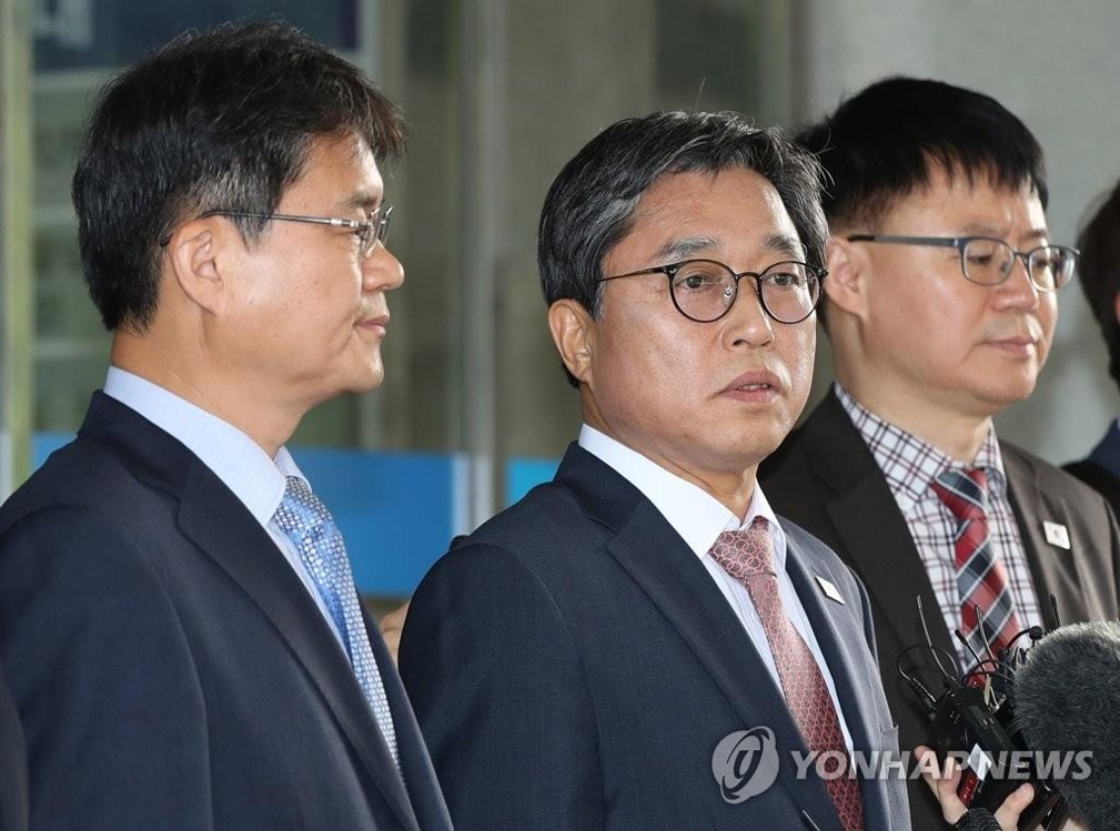 Jeon Choong-ryul (C), secretary general of the Korean Sport & Olympic Committee and head of a South Korean delegation, answers reporters' questions in Seoul before heading to Panmunjom for sports exchanges talks with North Korea on June 18, 2018. (Yonhap)