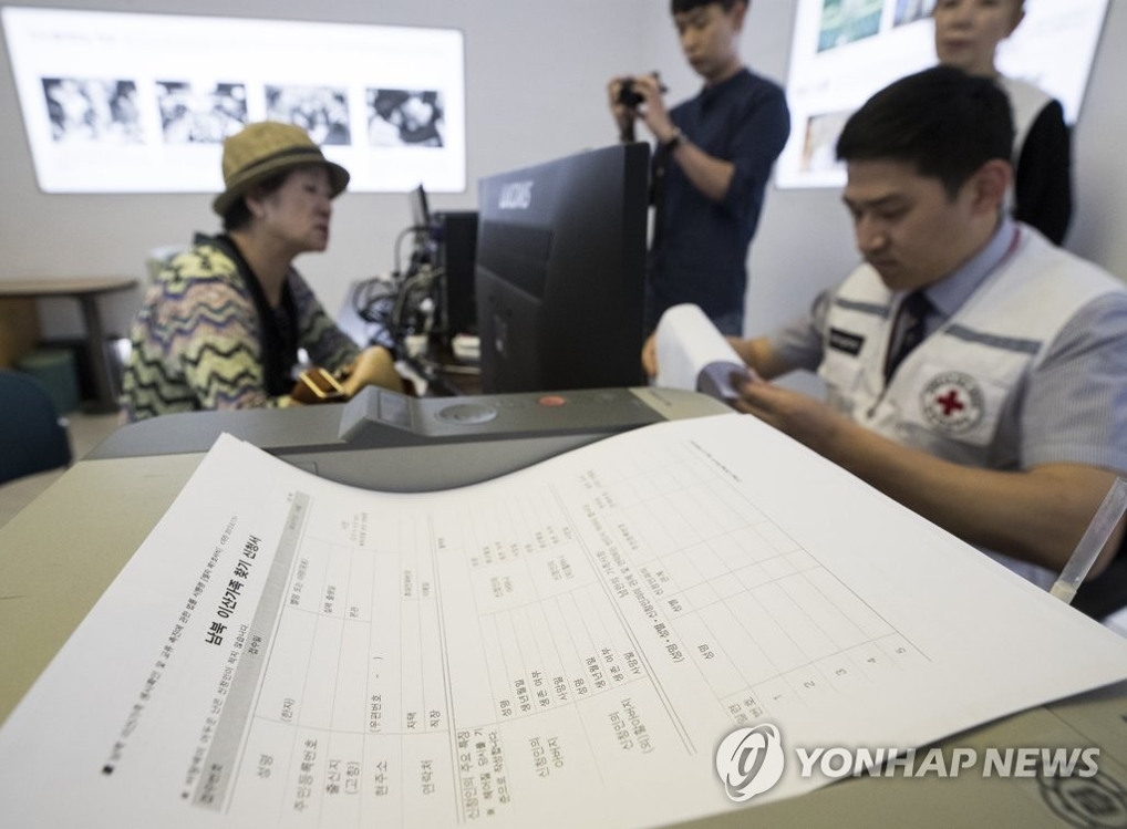 A South Korean woman talks with a Red Cross official to see if she can meet with her family in North Korea in this undated file photo. (Yonhap)