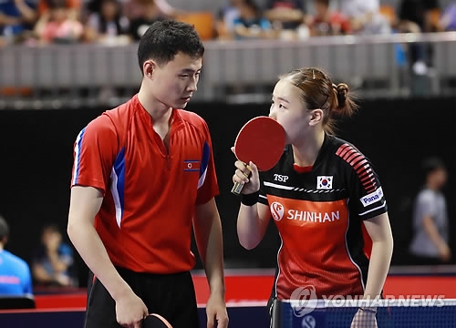 Choe Il of North Korea (L) and Yoo Eun-chong of South Korea speak during their mixed doubles round of 16 match against Lee Sang-su and Jeon Ji-hee of South Korea at the International Table Tennis Federation (ITTF) World Tour Platinum Korea Open at Chungmu Sports Arena in Daejeon, 160 kilometers south of Seoul, on July 19, 2018. (Yonhap)
