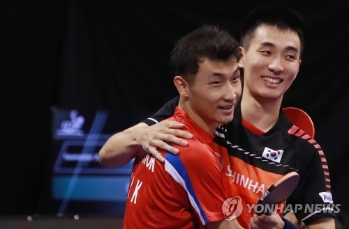 Pak Sin-hyok of North Korea (L) and Lee Sang-su of South Korea celebrate their victory over Liang Jingkun and Yan An of China in the men's doubles semifinals at the International Table Tennis Federation (ITTF) World Tour Platinum Korea Open at Chungmu Sports Arena in Daejeon, 160 kilometers south of Seoul, on July 20, 2018. (Yonhap)