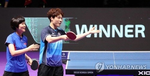 Cha Hyo-sim of North Korea (L) and Jang Woo-jin of South Korea celebrate their gold medal in the mixed doubles at the International Table Tennis Federation (ITTF) World Tour Platinum Korea Open at Chungmu Sports Arena in Daejeon, 160 kilometers south of Seoul, on July 21, 2018. (Yonhap)
