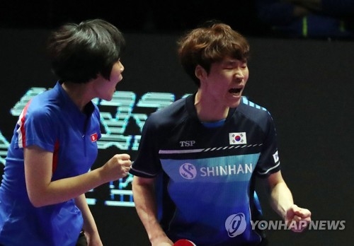 Cha Hyo-sim of North Korea (L) and Jang Woo-jin of South Korea celebrate their point against Wang Chuqin and Sun Yingsha of China in the mixed doubles final at the International Table Tennis Federation (ITTF) World Tour Platinum Korea Open at Chungmu Sports Arena in Daejeon, 160 kilometers south of Seoul, on July 21, 2018. Jang and Cha won the match 3-1 (5-11, 11-3, 11-4, 11-8). (Yonhap)