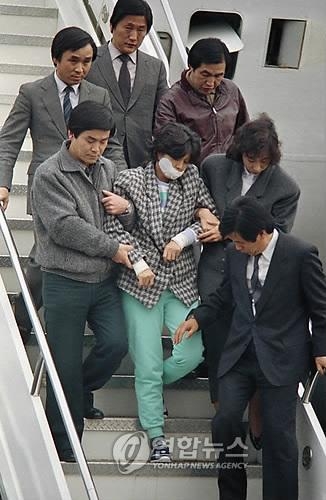 This file photo shows Kim Hyun-hui being taken out of a plane in South Korea by South Korean spy agents, with her mouth taped, on Dec. 15, 1987. (Yonhap)