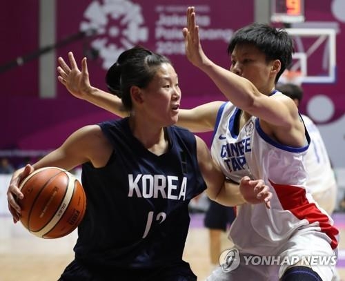 North Korean center Ro Suk-yong (L) of the unified Korean women's basketball team tries to drive past a Chinese Taipei player during a preliminary game at the 18th Asian Games at GBK Basketball Hall in Jakarta on Aug. 17, 2018. (Yonhap)