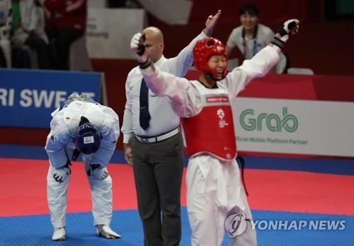 South Korea's Lee Ah-reum (L) reacts after losing to Luo Zongshi of China in the women's taekwondo 57-kilogram "kyorugi" (sparring) final at 18th Asian Games in Jakarta on Aug. 21, 2018. (Yonhap)