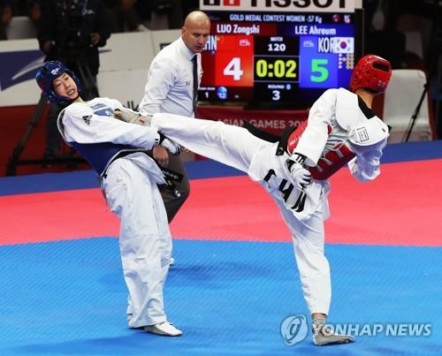 South Korea's Lee Ah-reum (L) gives up points to China's Luo Zongshi in the women's taekwondo 57-kilogram "kyorugi" (sparring) final at 18th Asian Games in Jakarta on Aug. 21, 2018. (Yonhap)