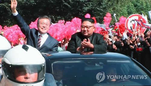 South Korean President Moon Jae-in (L) waves to North Koreans during a car parade through the streets of Pyongyang on Sept. 18. (Yonhap)