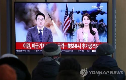 Citizens watch live news alerts on Iran's firing of missiles at U.S. bases in Iraq at Seoul Station in Seoul on Jan. 8, 2020. (Yonhap)