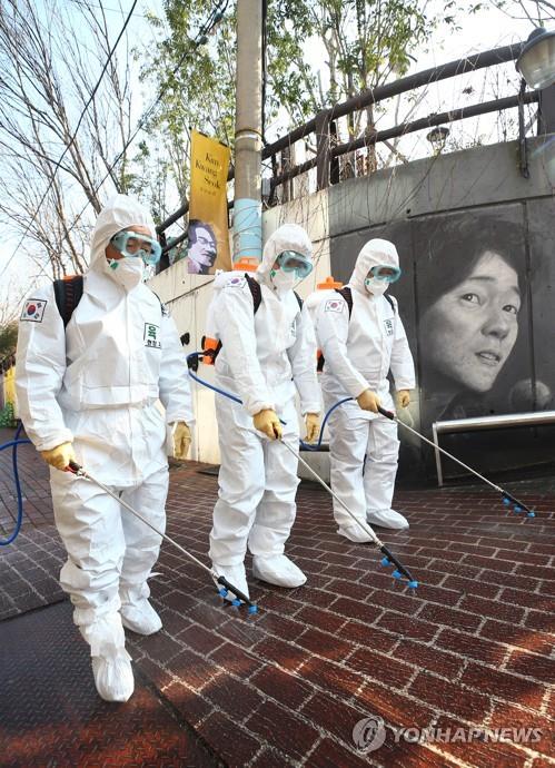 Soldiers disinfect Kim Kwang-seok Memorial Street, a famous tourist spot, in the southeastern city of Daegu on March 5, 2020, as part of preventive measures against the spread of the COVID-19 coronavirus. (Yonhap)