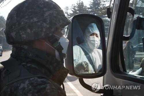 A service member checks a bus for quarantine work at an Army boot camp in the northern county of Yeoncheon on Nov. 26, 2020, after dozens of newly enlisted soldiers tested positive for the new coronavirus. (Yonhap)