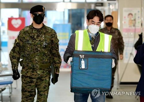 An official carrying a box containing doses of AstraZeneca's COVID-19 vaccine arrives at a public health care facility in the southeastern city of Daegu on Feb. 25, 2021, one day ahead of the start of the country's vaccination program. (Yonhap)