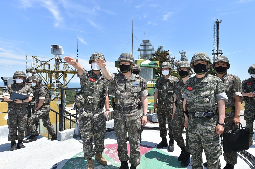 Joint Chiefs of Staff Chairman Gen. Won In-choul (C) checks the security situation in border areas during his visit to a military unit on the border island of Yeonpyeong in the Yellow Sea on June 16, 2021, in this photo providd by his office. (PHOTO NOT FOR SALE) (Yonhap)