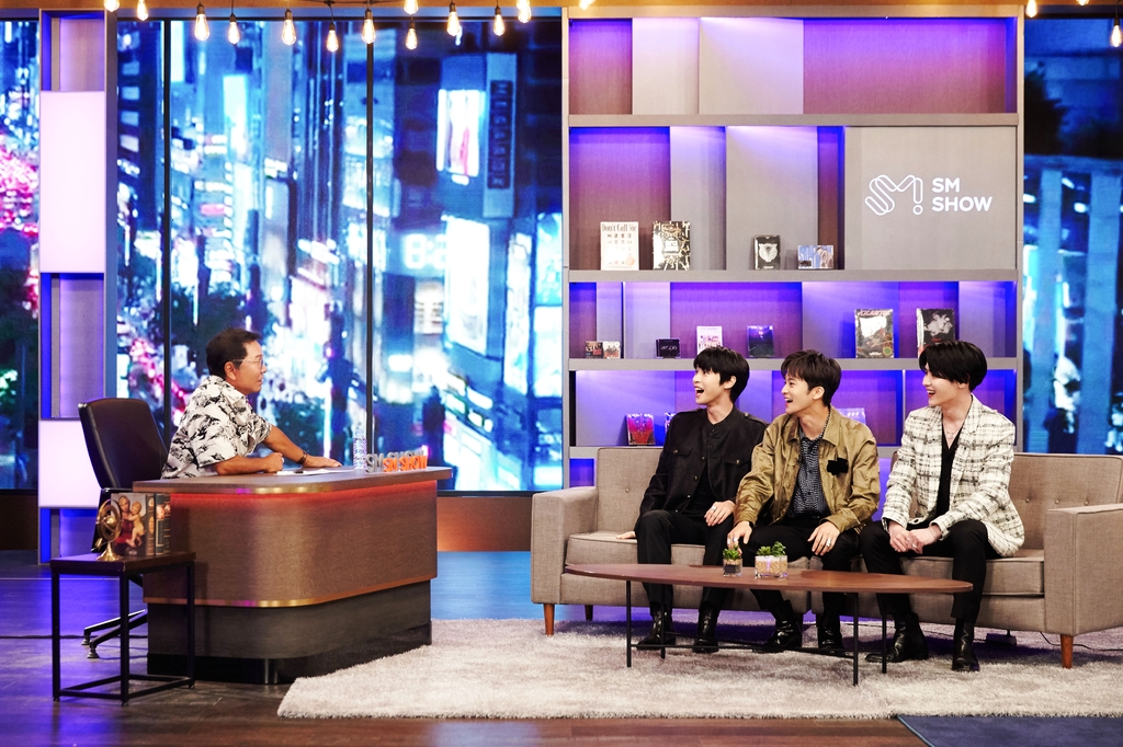 This photo, provided by SM Entertainment, shows the agency-label's chief producer Lee Soo-man speaking with some members of boy band NCT during a corporate event broadcast on June 29, 2021. (PHOTO NOT FOR SALE) (Yonhap)