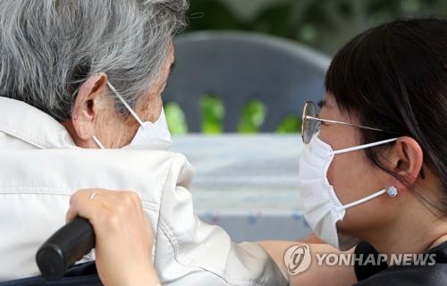 A woman speaks with her mother at a nursing home in Chuncheon, Gangwon Province, on the eve of the traditional holiday of Chuseok on Sept. 20, 2021. (Yonhap)