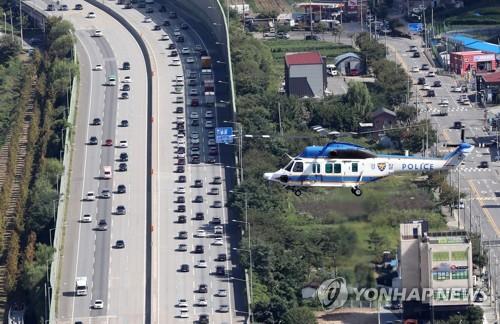 The southbound lanes of a highway in the city of Yongin, Gyeonggi Province, are clogged with heavy traffic on Sept. 20, 2021, with a police helicopter monitoring from above. (Pool photo) (Yonhap)