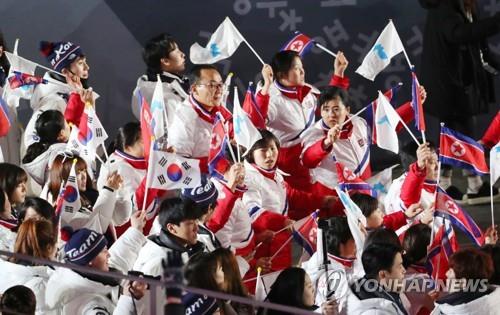 In this Feb. 25, 2018, file photo, South and North Korean athletes march during the closing ceremony of the PyeongChang Winter Olympics in Pyeongchang, waving their national and unified Korea flags. (Yonhap) 