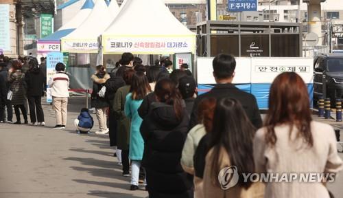 People wait in line to get tested for the coronavirus at a testing center near Seoul Station on March 10, 2022. (Yonhap)