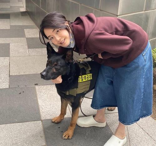 This undated photo provided by a reader shows Kim Keon-hee, the wife of President-elect Yoon Suk-yeol posing for with a bomb-sniffing dog near her residence in Seoul. (PHOTO NOT FOR SALE) (Yonhap)
