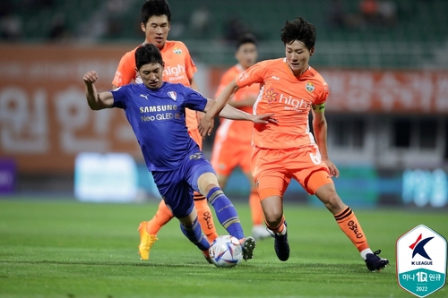 In this May 29, 2022, file photo provided by the Korea Professional Football League, Jang Ho-ik of Suwon Samsung Bluewings (L) and Kim Dong-hyun of Gangwon FC battle for the ball during the clubs' K League 1 match at Gangneung Stadium in Gangneung, 220 kilometers east of Seoul. (PHOTO NOT FOR SALE) (Yonhap)