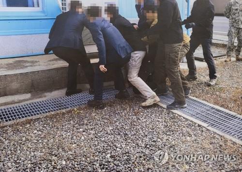 This photo, provided by the Ministry of Unification on July 12, 2022, shows a North Korean fishermen collapsing before South Korean authorities hand him over to North Korean authorities in the inter-Korean truce village of Panmunjom in November 2019. (PHOTO NOT FOR SALE) (Yonhap)
