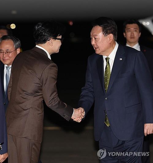 President Yoon Suk Yeol (R) shakes hands with People Power Party leader Han Dong-hoon upon arriving at Seoul Air Base, just south of Seoul, on Oct. 11, 2024, following a three-nation tour of Southeast Asia. (Yonhap)
