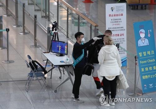 仁川空港国際線の出発ロビーで検温を受ける外国人(資料写真)=(聯合ニュース)