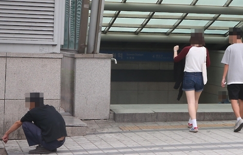 지하철 출입구서 담배 피우는 남성
