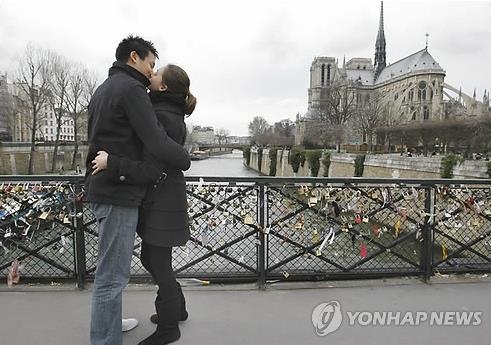 센 강 다리에서 입맞춤하는 프랑스 연인. 오른쪽으로 노트르담이 보인다.