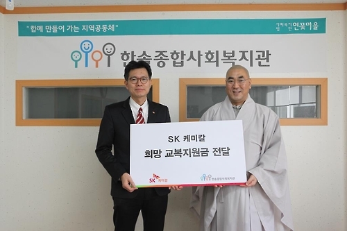 SK케미칼 홍보팀장(왼쪽)이 한솔종합복지관을 찾아 한솔종합복지관 가섭 관장(오른쪽)에게 복지관 소속 '희망메이커' 학생들이 입을 교복 지원금을 전달했다.
