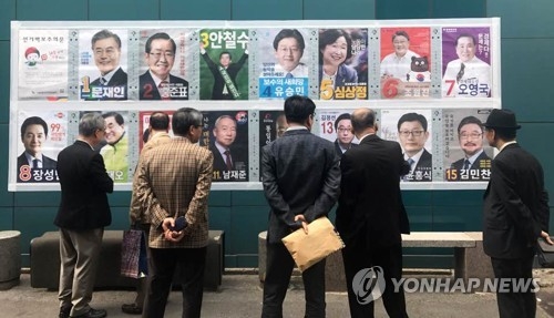 TV 토론 후 더 뜨거워진 대선 열기 '유권자의 선택은?' (서울=연합뉴스) 손형주 기자 = 제19대 대통령 선거를 15일 앞둔 24일 오후 서울 중구에서 유권자들이 선거 벽보를 보고 있다. 2017.4.24 handbrother@yna.co.kr (끝)