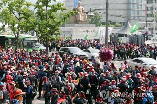 좁은 길 사이로(서울=연합뉴스) 정경재 기자 = 21일 오전 출근길에 오른 버스와 차량들이 서울 광화문 세종로에 모인 민주노총 산하 전국건설노조 조합원들 사이로 지나가고 있다. 건설노조는 전날부터 이곳에서 '토목건축 조합원 상경총회'를 갖고 건설현장 불법 근절과 고용 대책을 촉구하는 집회를 진행하고 있다. 2017.6.21jaya@yna.co.kr(끝)