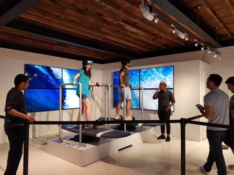 VR 기기로 서핑 체험을 하는 방문객들