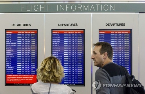 미국 시카고 미드웨이공항 이용객들이 대부분 항공편 운항이 취소된 안내판을 확인하고 있다. [AP=연합뉴스]