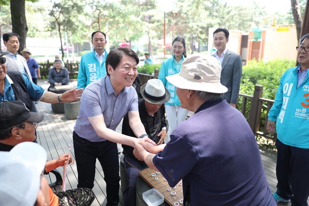 우이동 솔밭근린공원을 찾아 바둑 두는 어르신과 악수하는 안철수 후보