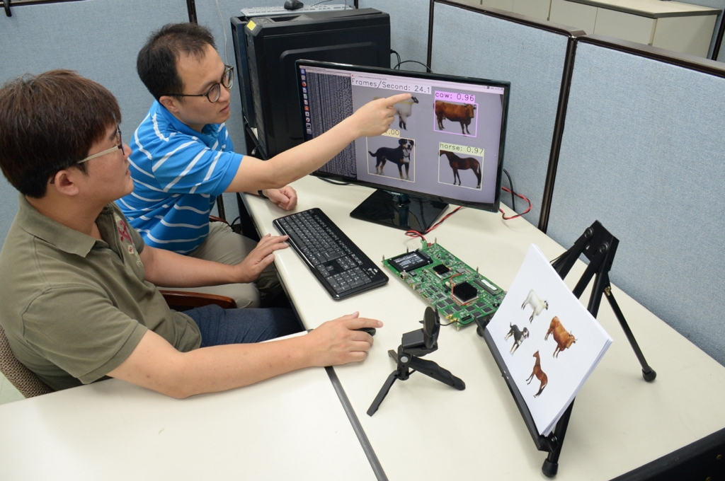 ETRI 김주엽 선임연구원(왼쪽)과 조민형 책임연구원이 시각지능 칩을 통해 사물인지 기술을 실험하는 모습 [ETRI 제공=연합뉴스]