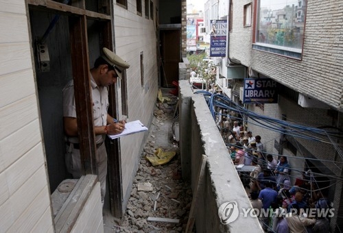 1일 인도 경찰이 시신 11구가 발견된 뉴델리 가정집에서조사 내용을 메모하고 있다. [로이터=연합뉴스]