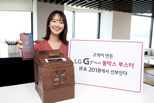 12일 모델이 서울 여의도에 위치한 LG트윈타워에서 붐박스 부스터 경진대회 '붐 유어 사운드' 최우수 작품을 소개하고 있다. 나무 통판으로 만든 이 작품은 대형 카세트 오디오를 연상시키는 디자인으로 레트로 감성을 더했다.