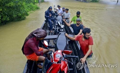 인도 케랄라 주 홍수 피해지역에서 주민들이 배를 타고 이동하고 있다. [AP=연합뉴스]
