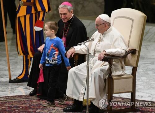 28일 바티칸에서 열린 수요일반알현에서 단상에 올라온 소년을 교황이 웃으면서 바라보고 있다. [AFP=연합뉴스] 