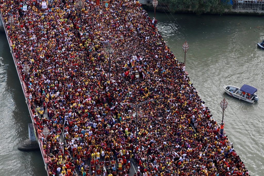 (마닐라 EPA=연합뉴스) '블랙 나자렌'(Black Nazarene) 퍼레이드에서 참가자들이 키아포 성당으로 가기 위해 다리를 건너고 있다.