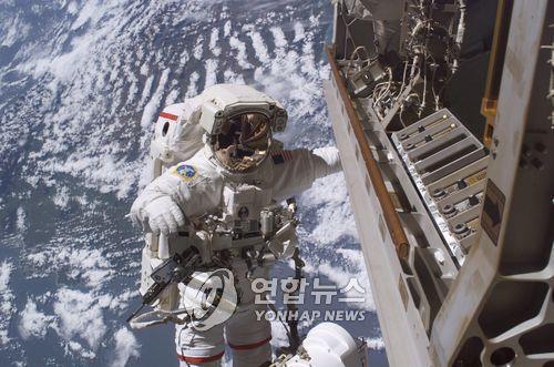 ISS 밖에서 카메라 장비를 교체 중인 미국 우주인 